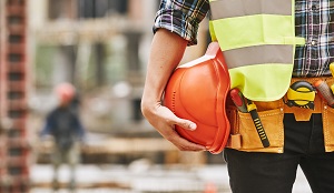 close of up construction worker holding orange hard hat